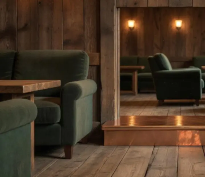 Warm lounge entrance with timber paneling and copper accents at AGNIESZKA ADACH WERSA.